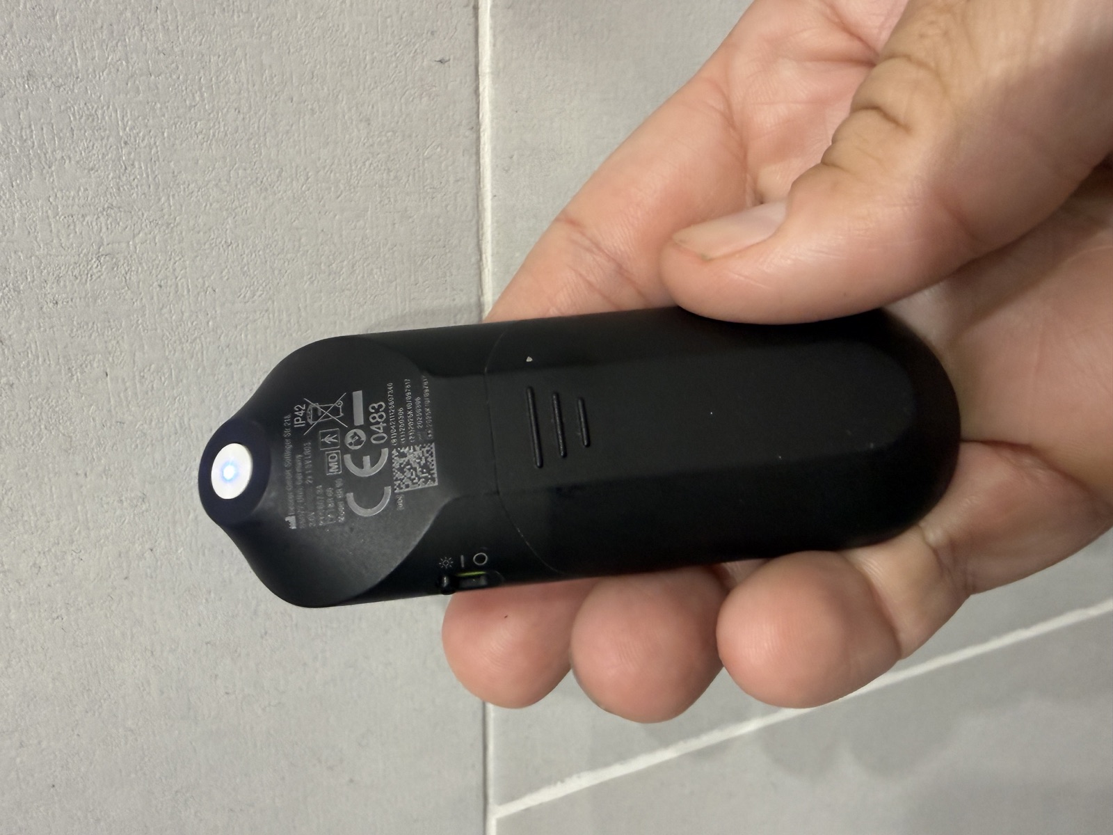 Le dos du Beurer BiteX Day&Night avec la lumière blanche BiteSpotLight allumée, les marquages IP42 et Model BR 90, le compartiment à piles et l'interrupteur de la lampe