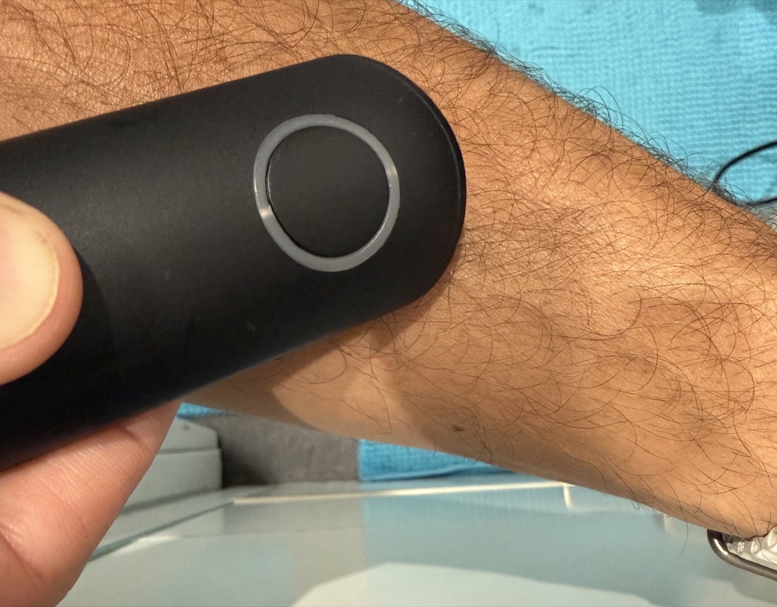 Application de la pastille chauffante du Beurer BiteX sur l'avant-bras, au-dessus du lavabo de la salle de bain